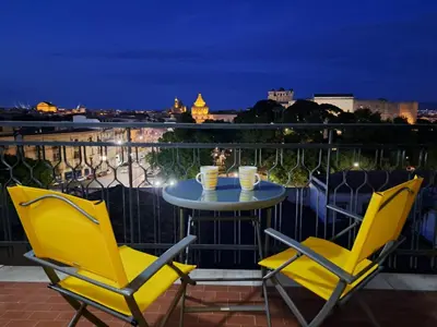 two chairs and a table on a balcony at night at Skyline Palermo in Palermo