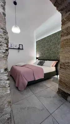 a bedroom with a bed and a brick wall at LA SPLENDIDA Dimora di Charme - Luxury Loft Palermo in Palermo