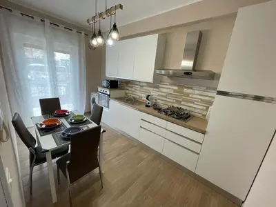 a kitchen with a table with chairs and a refrigerator at Panormus Guest Apartment in Palermo