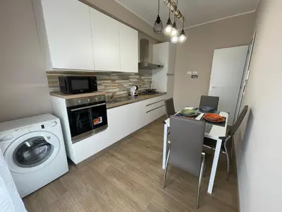 a kitchen with a washing machine and a table with chairs at Panormus Guest Apartment in Palermo