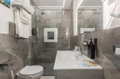 a bathroom with a sink and a toilet and a shower at Apartment al Vicolo 27 in Palermo