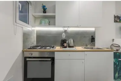 a white kitchen with a stove and a sink at Apartment al Vicolo 27 in Palermo