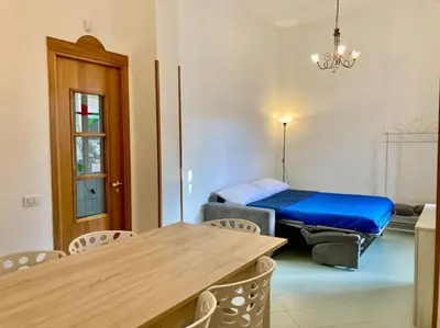 a room with a bed and a table and chairs at Villa Orlando Mondello in Palermo