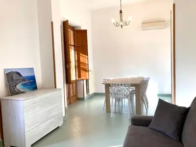 a living room with a dining room table and a couch at Villa Orlando Mondello in Palermo