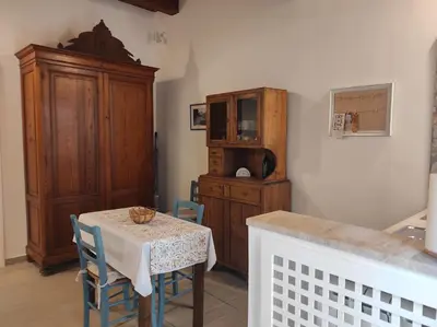 a dining room with a table and a wooden cabinet at Guzzari 75 Home in Castellammare del Golfo