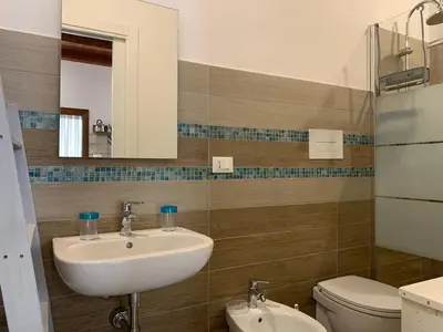 a bathroom with a sink and a toilet and a mirror at Guzzari 75 Home in Castellammare del Golfo