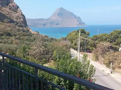 a view of a mountain and the ocean from a balcony at Makari Sweet Sunsets in Macari