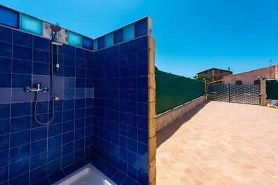 a blue tiled shower with a tub in a yard at Villa Diamante in Campofelice di Roccella
