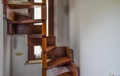 a wooden spiral staircase in a room with a window at Awesome Apartment In Trabia in Trabia