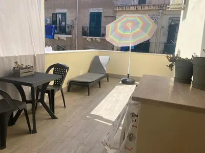 a patio with a table and chairs and an umbrella at Appartamento Florio in Palermo