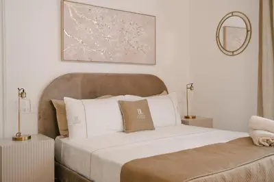 a bedroom with a large white bed with a brown headboard at La Duca Suites & Apartments in Palermo