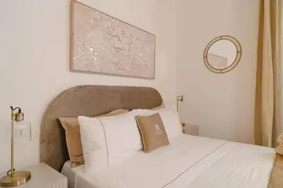 a bed with white sheets and pillows in a bedroom at La Duca Suites & Apartments in Palermo