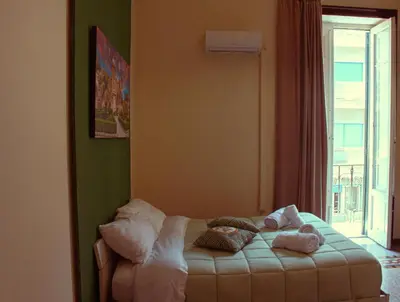 a small bed in a room with a window at Mizzica Rooms in Palermo