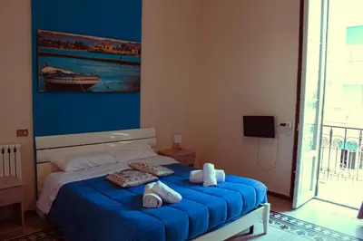a bedroom with a blue bed with towels on it at Mizzica Rooms in Palermo