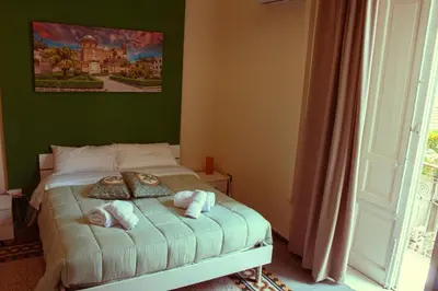 a bedroom with a bed with towels on it at Mizzica Rooms in Palermo