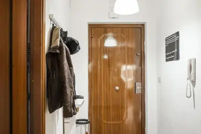 a hallway with a door and a coat hanging on a wall at New Stabile APT Balcony central apartment in Palermo