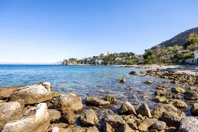 a beach with rocks in the water at Casa Eugenia in Santa Flavia