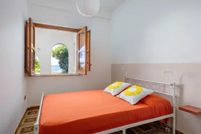 a bedroom with an orange bed with a mirror at Casa Eugenia in Santa Flavia