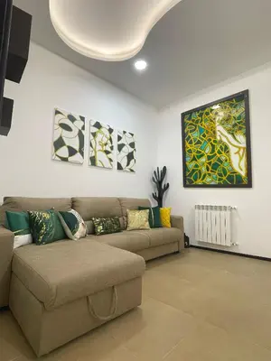 a living room with a couch and paintings on the wall at La casa di Alice in Palermo
