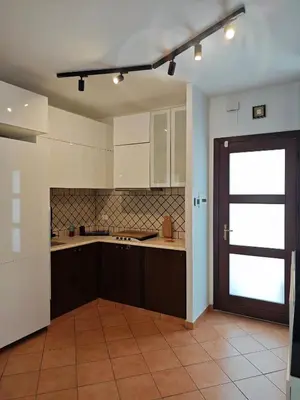 a kitchen with white cabinets and a brown door at NBHouse in Palermo
