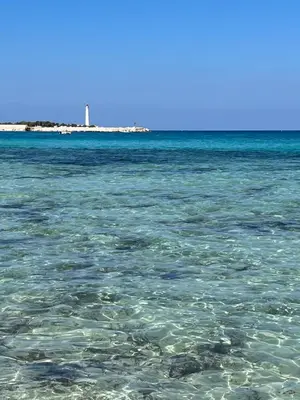a view of the ocean with a lighthouse in the background at Il Fico d'India in San Vito lo Capo