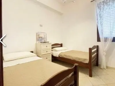 a bedroom with two beds and a dresser and a window at Il Fico d'India in San Vito lo Capo