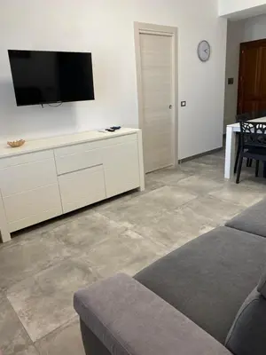 a living room with a flat screen tv on the wall at San Vito Holiday Home in San Vito lo Capo