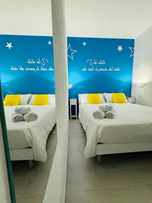 two beds in a room with a blue wall with stars at Sirio rooms and apartments in Carini