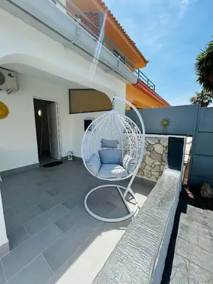 a white wicker chair sitting on a patio at Sirio rooms and apartments in Carini