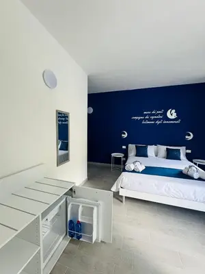 a bedroom with a large bed with a blue wall at Sirio rooms and apartments in Carini