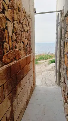 a brick wall with an open door to the ocean at LA TERRAZZA SUL MARE camera vicino aereoporto&mare SICILIAN VINTAGE STYLE SEASIDE ROOM in Cinisi