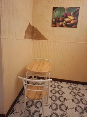 a table and a chair sitting in a room at LA TERRAZZA SUL MARE camera vicino aereoporto&mare SICILIAN VINTAGE STYLE SEASIDE ROOM in Cinisi