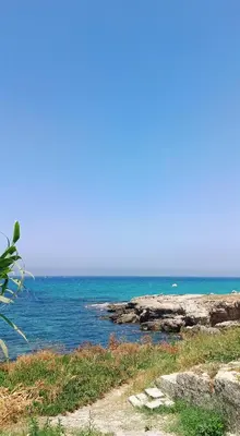 a beach with the ocean in the background at LA TERRAZZA SUL MARE camera vicino aereoporto&mare SICILIAN VINTAGE STYLE SEASIDE ROOM in Cinisi