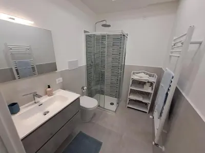 a white bathroom with a sink and a shower at Casa cannella in Palermo