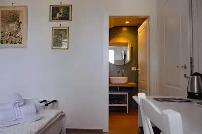 a white room with a table and a bathroom at Villa Rubino, Addaura - Mondello in Palermo