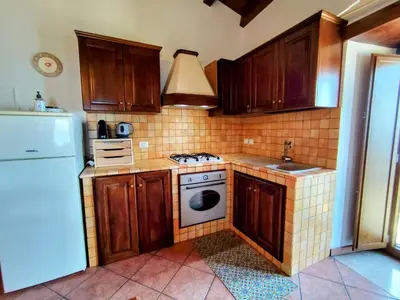 a kitchen with wooden cabinets and a white stove top oven at Open Space Marianna - Sea View in Trabia