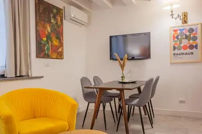 a dining room with a yellow chair and a table at Resuttano Loft in Palermo