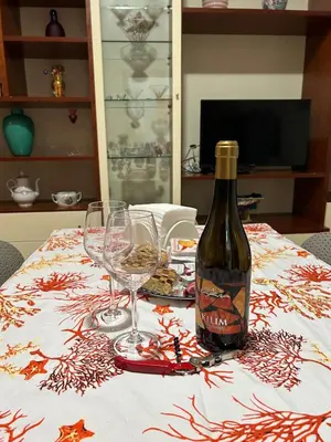 a bottle of wine sitting on a table with glasses at Conchiglia azzurra in Trappeto