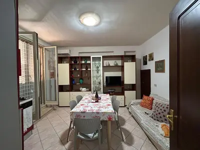 a dining room with a table and a couch at Conchiglia azzurra in Trappeto