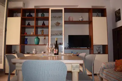 a dining room with a table with chairs and a television at Conchiglia azzurra in Trappeto
