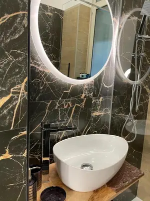 a bathroom with a white sink and a mirror at Baglio porta d Ossuna in Palermo