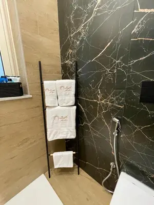 a bathroom with a black marble wall and towels at Baglio porta d Ossuna in Palermo