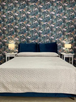 a bedroom with a bed with a floral wallpaper at Baglio porta d Ossuna in Palermo