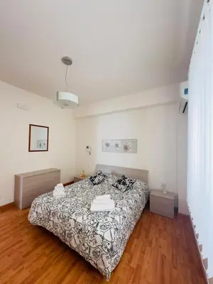 a bedroom with a bed and a wooden floor at Balestrate Mare Centro Wi-Fi Self Check-in Aria Condizionata in Balestrate