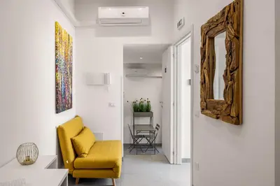 a living room with a couch and a staircase at Casa Azzurra Rooms e apartment in Terrasini