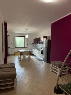 a kitchen with a table and a purple wall at Fun House in Trabia