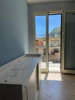 a white kitchen with a view of a balcony at Fun House in Trabia