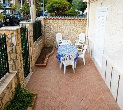 a patio with a table and chairs and a stone wall at Pegaso 15 Home in Palermo
