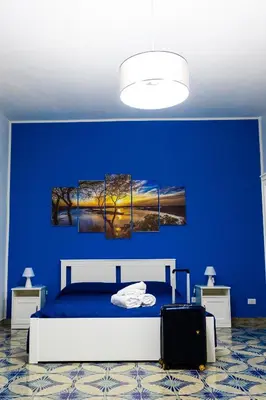 a blue bedroom with a bed and a blue wall at Pegaso 15 Home in Palermo
