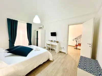a bedroom with a bed and a desk with a television at Domus Livi in Cinisi